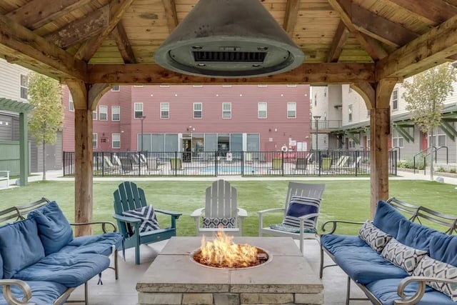 Blue couches fire pit chairs outdoor living area at Hannah Townhomes & Lofts in East Lansing Student Accommodation