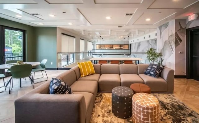 Sofa pillows ottomans table chairs dining area living room at Signature Hartwell Village in Seneca Student Accommodation