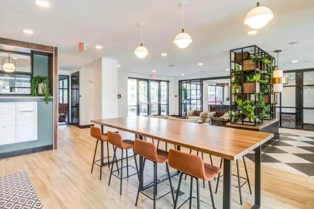 Long wooden table with orange bar stools communal area at Signature Hartwell Village in Seneca Student Accommodation