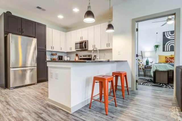 Kitchen with stainless steel appliances and orange stools kitchen at Signature Hartwell Village in Seneca Student Accommodation