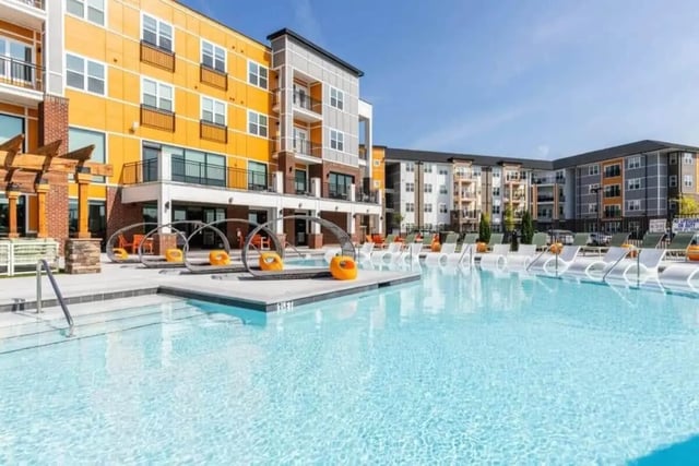 Pool with lounge chairs and modern buildings exterior at Signature Hartwell Village in Seneca Student Accommodation