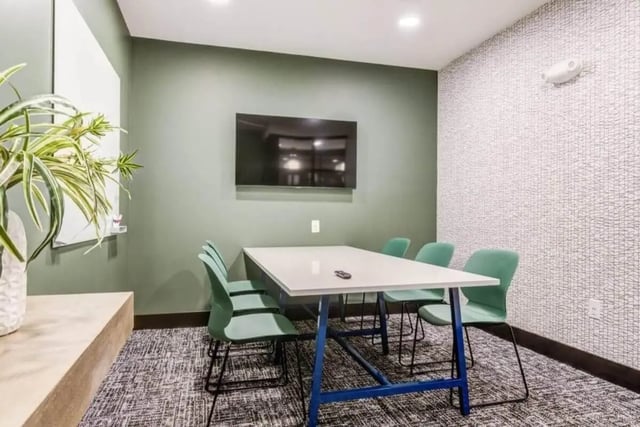 Table chairs whiteboard television study area at Signature Hartwell Village in Seneca Student Accommodation