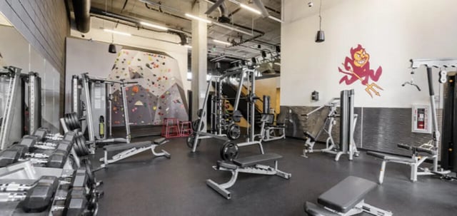 Gym equipment dumbbells climbing wall fitness area at Vertex Apartments in Tempe Student Accommodation