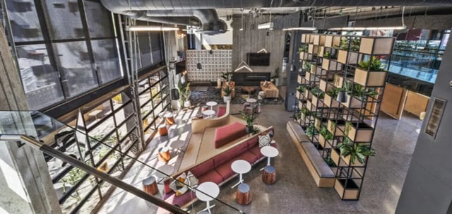 Red sofa, plants, lounge seating, communal area at Vertex Apartments in Tempe Student Accommodation