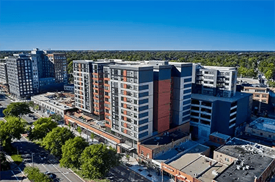 Modern apartment complex with brick and gray exterior exterior at Landmark on Grand River in East Lansing Student Accommodation