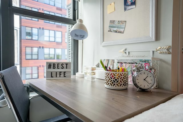 Desk with chair lightbox and alarm clock study area at Landmark on Grand River in East Lansing Student Accommodation