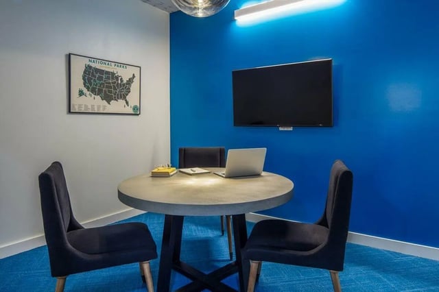 Round table chairs laptop and TV study area at Muse on Main in Pullman Student Accommodation