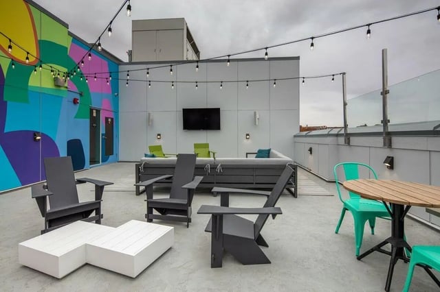 Rooftop lounge area with seating dining and colorful wall exterior at Muse on Main in Pullman Student Accommodation