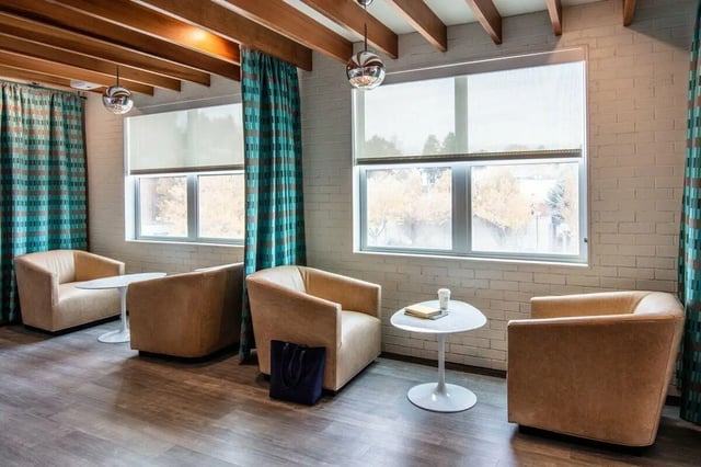 Chairs tables tote bag windows common area at Muse on Main in Pullman Student Accommodation