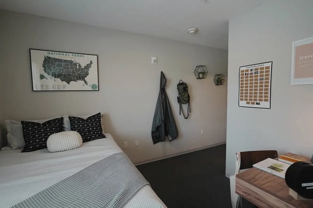 Bed desk coat rack and wall decor bedroom at Muse on Main in Pullman Student Accommodation