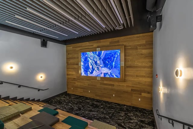 Tiered seating with cushions and large screen Cinema at Merced Station in Merced Student Accommodation