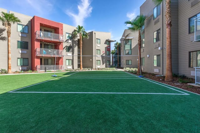 Volleyball court with surrounding apartment buildings exterior at Merced Station in Merced Student Accommodation