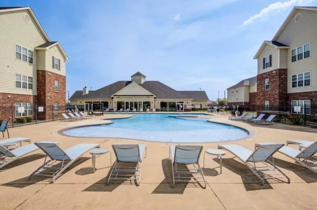 Loungers surround a resort-style swimming pool exterior at Mustang Village in Wichita Falls Student Accommodation