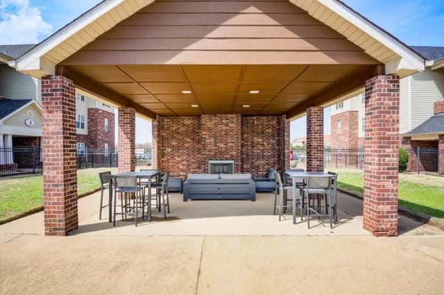 Outdoor lounge area with tables seating and fireplace Living room at Mustang Village in Wichita Falls Student Accommodation