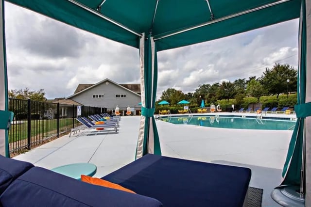 Poolside lounge chairs umbrellas swimming pool playing area at University Village At Clemson in Central Student Accommodation