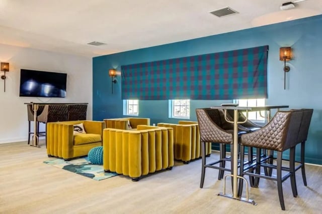 Yellow couches TV and bar area living room at University Village At Clemson in Central Student Accommodation