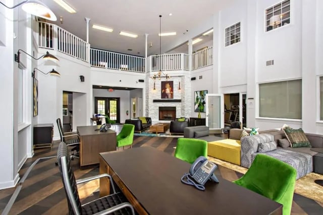 Desks chairs phones sofas fireplace common area living room at University Village At Clemson in Central Student Accommodation