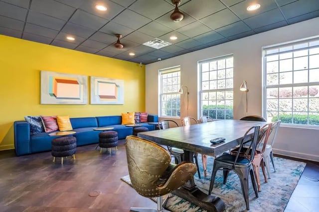 Blue sectional sofa dining table artwork and chairs living room at University Village At Clemson in Central Student Accommodation