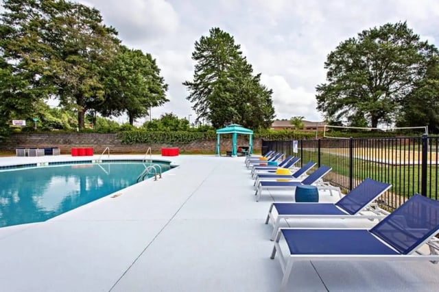 Pool lounge chairs and volleyball court exterior at University Village At Clemson in Central Student Accommodation