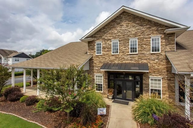 Stone building entrance with porch and landscaping exterior at University Village At Clemson in Central Student Accommodation