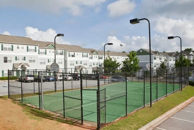 Apartment buildings with court fence and parking area exterior at University Village At Clemson in Central Student Accommodation