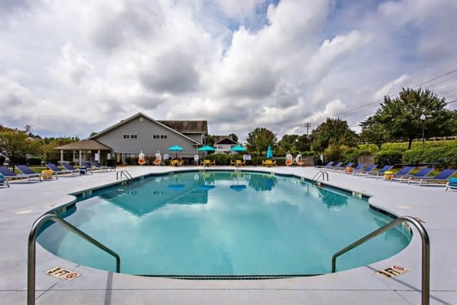 Pool with lounge chairs and building exterior at University Village At Clemson in Central Student Accommodation