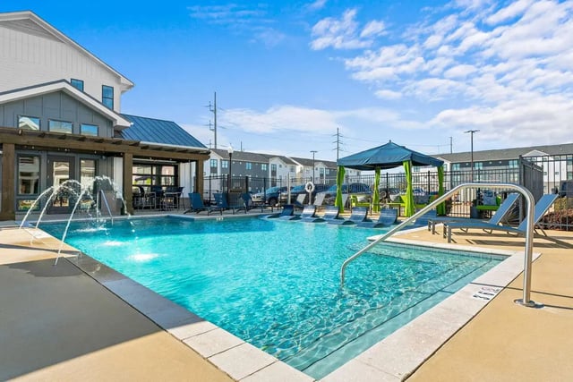 Swimming pool with lounge chairs and canopy outdoor area at My House on 13th in Tuscaloosa Student Accommodation