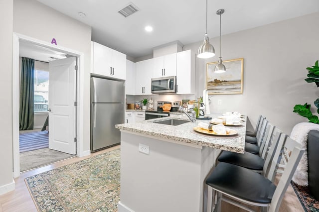 Modern kitchen with island seating dining area at My House on 13th in Tuscaloosa Student Accommodation