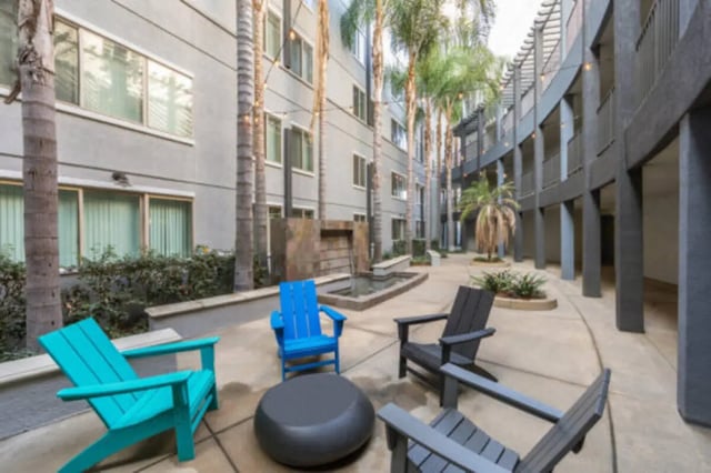Four colorful Adirondack chairs with a round table exterior at University Village Towers in Riverside Student Accommodation