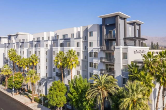 Modern apartment building with balconies and palm trees Exterior at University Village Towers in Riverside Student Accommodation
