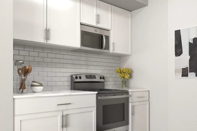 White cabinets microwave stove flowers kitchen at Hawks Pointe in Lawrence Student Accommodation
