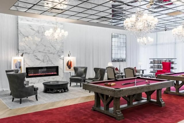 Fireplace pool tables chairs chandeliers recreational area at Vesper Holdings