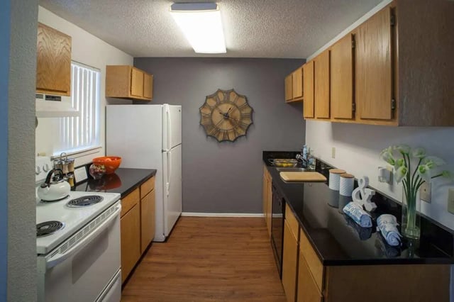 White refrigerator wooden cabinets clock kitchen at Hawks Pointe in Lawrence Student Accommodation