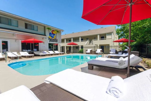 Swimming pool with loungers and umbrellas outdoor area at Hawks Pointe in Lawrence Student Accommodation