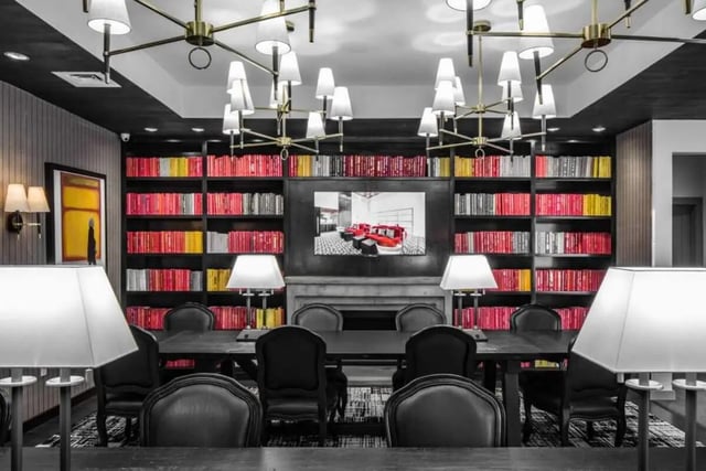 Bookshelves with colorful books surrounding a TV lounge area at Vesper Holdings