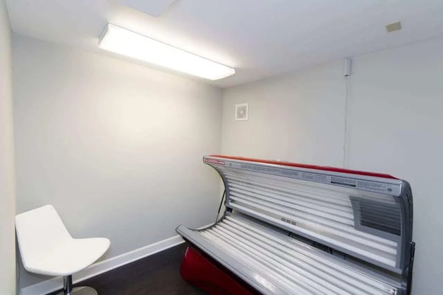 Tanning bed and white chair interior at Hawks Pointe II in Lawrence Student Accommodation