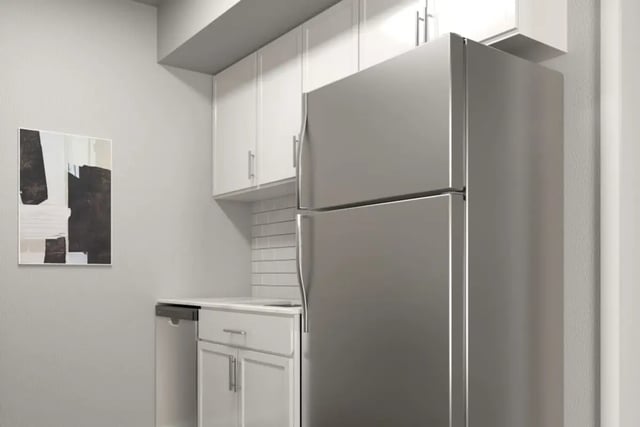 Modern stainless steel refrigerator white cabinets artwork kitchen at Hawks Pointe II in Lawrence Student Accommodation