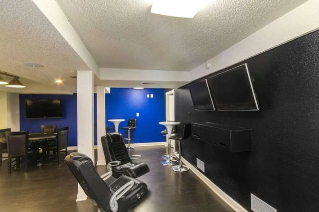 Gaming chairs bar stools TVs living room at Hawks Pointe II in Lawrence Student Accommodation
