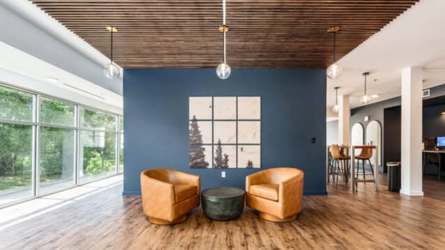 Two leather chairs coffee table wall art living room at The Vista Apartments in Boise Student Accommodation