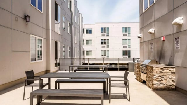 Outdoor seating area with grill and tables exterior at The Vista Apartments in Boise Student Accommodation
