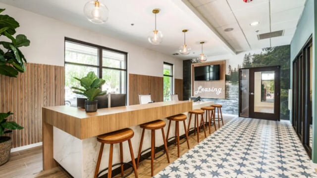 Leasing desk with stools and plants lobby area at The Vista Apartments in Boise Student Accommodation