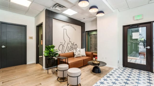 Brown sofa with stools wall art and coffee table common area at The Vista Apartments in Boise Student Accommodation
