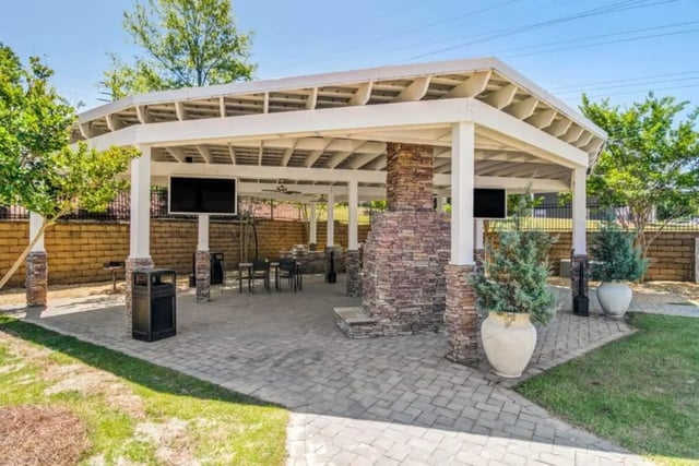 Covered outdoor lounge with TVs and seating area at The Collective At Auburn in Auburn Student Accommodation