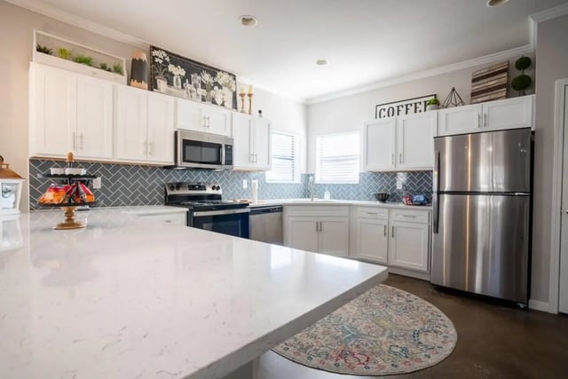 White cabinets stainless steel appliances tiled backsplash kitchen at The Collective At Auburn in Auburn Student Accommodation