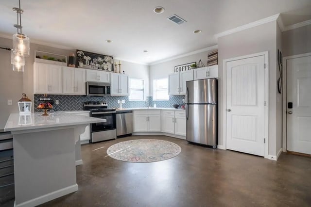 White cabinets stainless appliances island kitchen at The Collective At Auburn in Auburn Student Accommodation