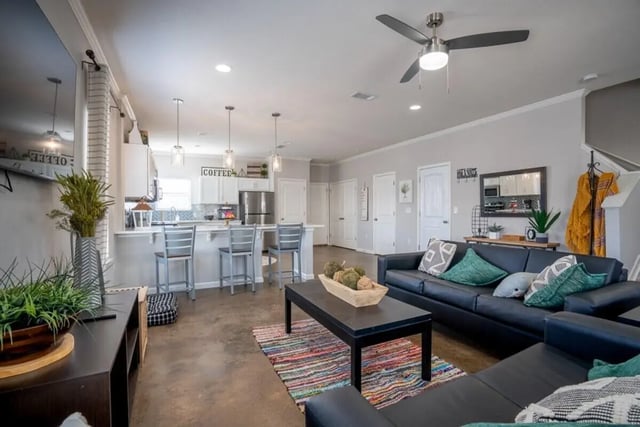 Sofa coffee table bar stools kitchen living room at The Collective At Auburn in Auburn Student Accommodation