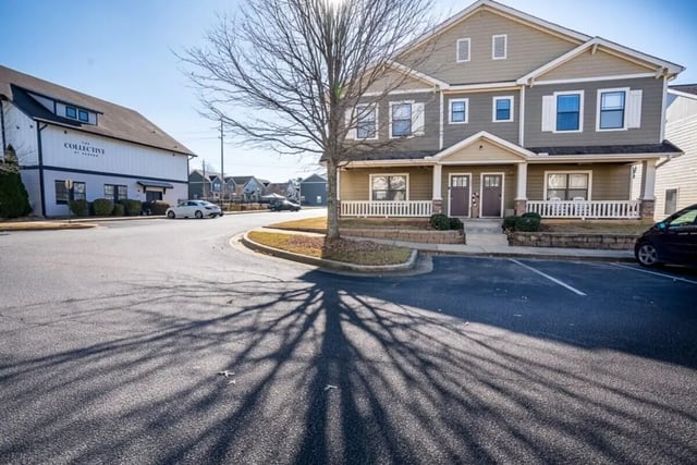 Townhouses with front porches parking lot exterior. at The Collective At Auburn in Auburn Student Accommodation