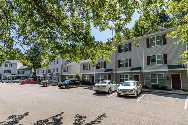 Townhouses with cars in parking lot exterior at Method Townhomes in Raleigh Student Accommodation