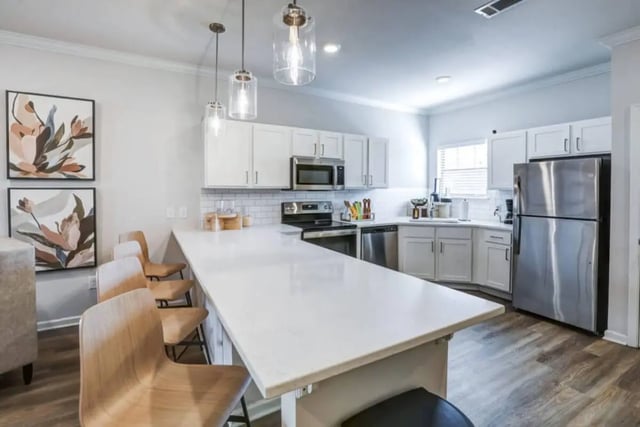 Modern white kitchen with island and appliances kitchen at The Collective At Clemson in Clemson Student Accommodation