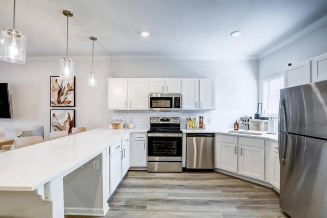 White cabinets stainless steel appliances and island kitchen at The Collective At Clemson in Clemson Student Accommodation